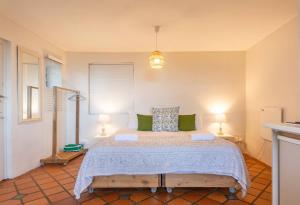 ein Schlafzimmer mit einem großen Bett mit grünen Kissen in der Unterkunft St James Garden Cottage in St James