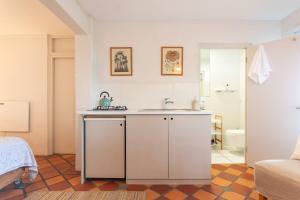 eine weiße Küche mit einem Waschbecken und ein Badezimmer in der Unterkunft St James Garden Cottage in St James