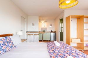a bedroom with a large bed and a kitchen at St James Pool Cottage in St James