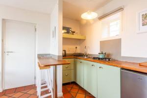 a kitchen with white cabinets and a wooden counter top at St James Pool Cottage in St. James