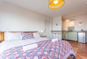 a bedroom with a large bed and a kitchen at St James Pool Cottage in St James