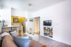 a living room with a couch and a kitchen at Malloom Cottage in Cape Town +13 photos