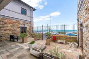 a patio with plants and a brick building at Malloom Cottage in Cape Town