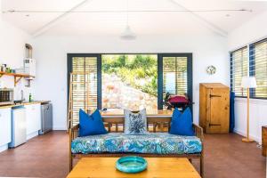 a living room with a couch and a table at Modern Beach Apartment in Kalk Bay