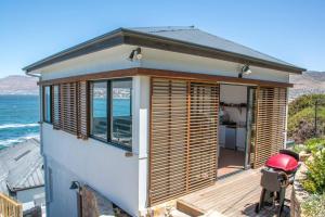 a tiny house with a view of the ocean at Modern Beach Apartment in Kalk Bay +22 photos