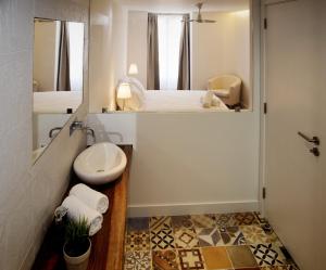 a bathroom with a sink and a toilet in a room at GS Chiado Boutique Studios & Suites in Lisbon +65 photos