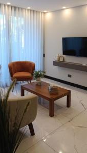 ein Wohnzimmer mit einem Couchtisch und einem Stuhl in der Unterkunft Luxia Sky Deluxe Equipetrol in Santa Cruz de la Sierra