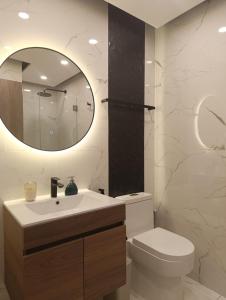 ein Badezimmer mit Waschbecken, Toilette und Spiegel in der Unterkunft Luxia Sky Deluxe Equipetrol in Santa Cruz de la Sierra