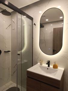 ein Badezimmer mit Waschbecken und Spiegel in der Unterkunft Luxia Sky Deluxe Equipetrol in Santa Cruz de la Sierra + 16 Fotos