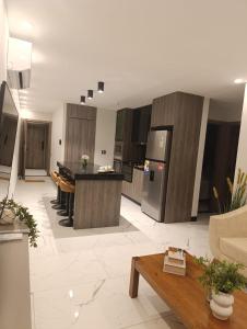 eine große Küche und ein Wohnzimmer mit einem Tisch in der Unterkunft Luxia Sky Deluxe Equipetrol in Santa Cruz de la Sierra