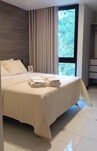 ein Schlafzimmer mit einem Bett mit zwei Handtüchern darauf in der Unterkunft Luxia Sky Deluxe Equipetrol in Santa Cruz de la Sierra