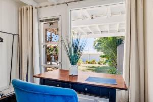 a table and a blue chair in a room with a window at The Grand Escape - Casita Sonrisa in Summerland