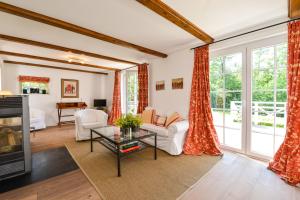 a living room with red curtains and a tv at Michels Huus - Schloss Gelting in Gelting