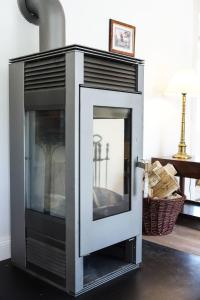 a fireplace with a glass door in a living room at Michels Huus - Schloss Gelting in Gelting