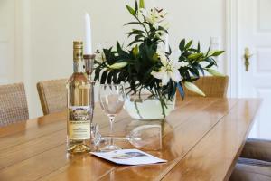a bottle of wine and two glasses on a wooden table at Michels Huus - Schloss Gelting in Gelting +17 photos