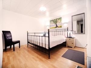 a bedroom with a bed and a chair and a mirror at Ferienhaus SEERESIDENZ am Mühlensee in Godern +17 photos