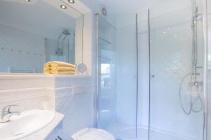 une salle de bain avec une douche, des toilettes et un lavabo dans l'établissement Windeby 1E, à Wenningstedt