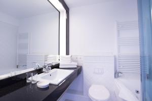 une salle de bain avec un lavabo, des toilettes et une douche dans l'établissement Windeby 1E, à Wenningstedt 17 autres photos