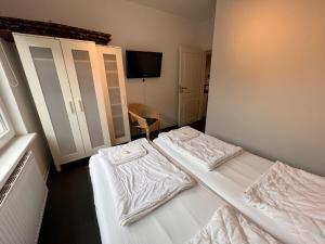 two beds in a hotel room with white sheets at Leuchtfeuer Fewo "Jens" in Börgerende-Rethwisch +11 photos