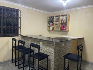 Un bar con taburetes negros en una habitación. en Idyllic Inn, en Lilongwe 12 fotos más