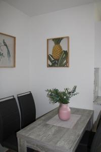 a dining room table with a vase on top of it at Leer, Haus Benefit in Evenburg