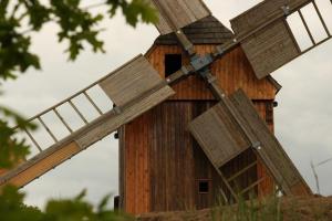 a wooden barn with a windmill at Ferienwohnung Windmühlenberg kein Monteurzimmer in Drehna