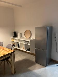 una cucina con frigorifero in acciaio inox e tavolo di Ferienwohnung in Spalt bis 5 Personen a Spalt
