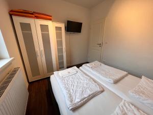 a bedroom with two beds and a tv on the wall at Leuchtfeuer Fewo "Kimberly" in Börgerende-Rethwisch