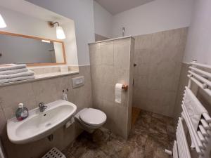 a bathroom with a white toilet and a sink at Leuchtfeuer Fewo "Kimberly" in Börgerende-Rethwisch +3 photos
