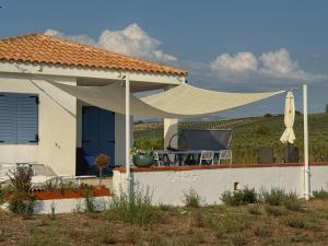 una casa bianca con ombrellone e tavolo e sedie di Fin Fiori a Menfi