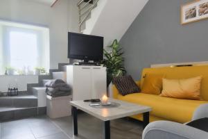 a living room with a yellow couch and a table with a candle at Ferienhaus Maja in Pavicini