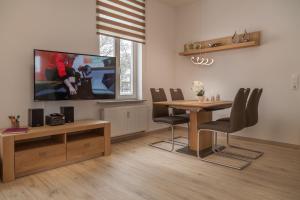 a dining room with a table and a tv at Am Schlosspark in Bad Harzburg