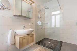 a white bathroom with a sink and a shower at Am Schlosspark in Bad Harzburg