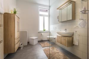 a white bathroom with a sink and a toilet at Am Schlosspark in Bad Harzburg