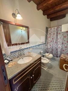 a bathroom with a sink and a toilet and a mirror at Villa Federica "UnaNotteaCasaMia" in Sacrofano +40 photos