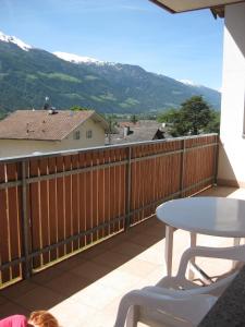 a table and chair on a balcony with mountains at Ferienwohnung im Haus Texel IV in Rablà