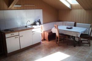 a small kitchen with a table and a sink at Spreewälder Schwalbenhof - Ferienwohnung "Nistkasten" in Golßen