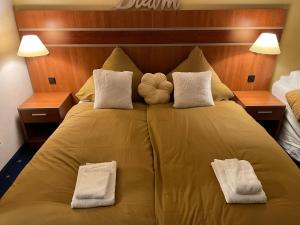 Una cama grande amarilla con dos almohadas encima. en Bergluft, en Hahnenklee-Bockswiese