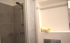 a bathroom with a shower with a yellow towel at Resi F8 in Prerow +4 photos