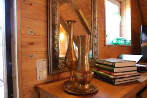 two vases and books on a table with a mirror at Haus Tanne - Obergeschoss Stausee-Hausde in Neumühle