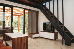 a living room with a staircase in a house at House Stone house with jacuzzi in Lukoran