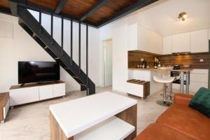 a living room with a couch and a tv and a staircase at House Stone house with jacuzzi in Lukoran