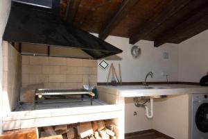 a kitchen with a stove and a counter with a sink at House Stone house with jacuzzi in Lukoran +17 photos