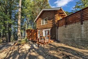 Cabaña de madera en el bosque con porche en Mays Luxury Farmstay, en Los Gatos