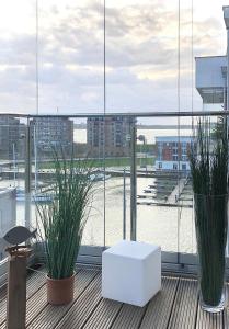 a balcony with two potted plants and a white box at Port Marina "Schlagseite" in Bremerhaven