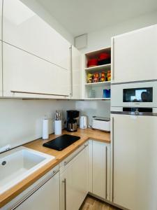 a kitchen with white cabinets and a sink at Port Marina "Schlagseite" in Bremerhaven