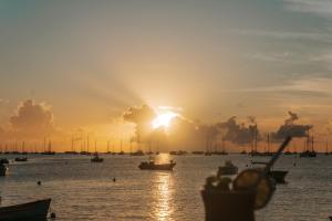a sunset over a body of water with boats at Hotel-Restaurant La Dunette in Sainte-Anne