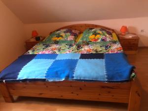 a bed with a blue comforter on top of it at Ferienhaus Ostfriesland in Berumbur