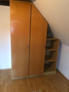 a wooden cabinet in the corner of a room at Ferienhaus Ostfriesland in Berumbur +11 photos