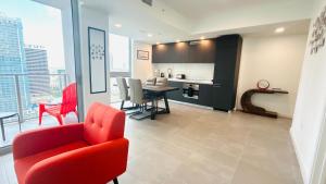 a living room with a red chair and a table at Sky-High oasis heated Pool & Gym Miami Skyline Vista in Miami